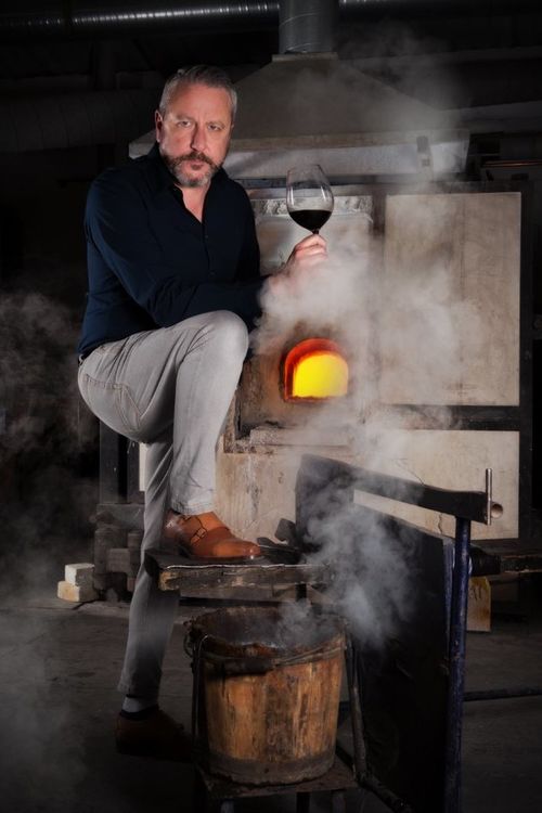 Neil Hughes warms his Rioja by the Dartington furnace , with his Dexter double monks 